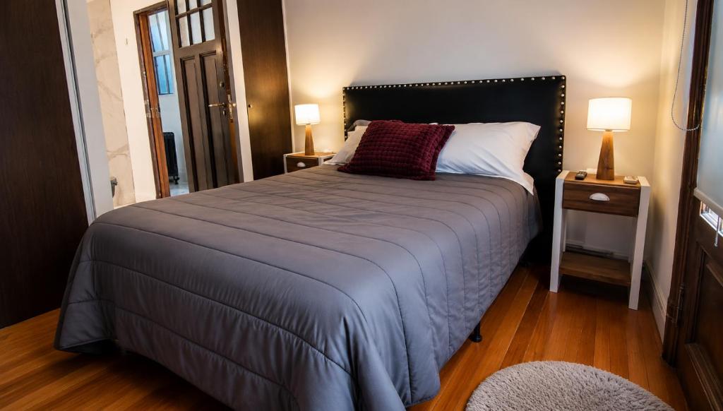 Cama principal con veladores y piso de madera refinado